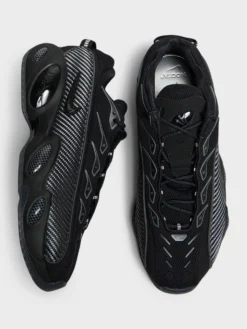 Nocta Glide Sneakers i Black, Black, Iron Grey og University Gold
